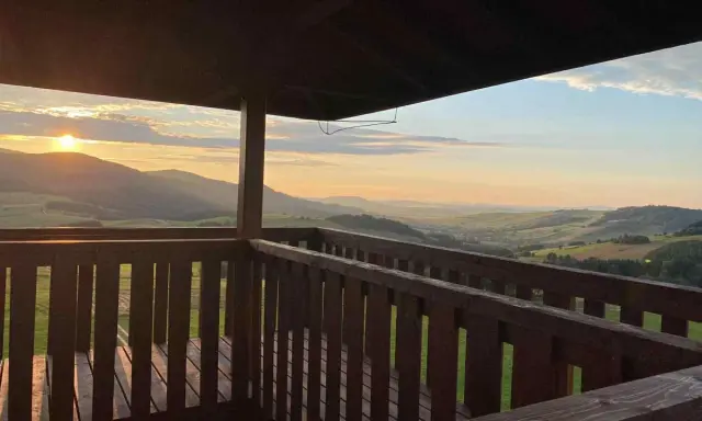 Widok z wieży widokowej na malownicze **beskid niski szczyty** o zachodzie słońca.