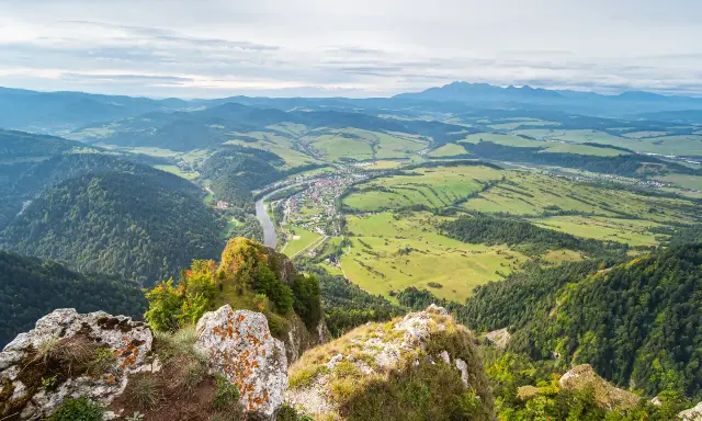 Widok z góry na dolinę z rzeką i miasteczkiem, w oddali majaczą góry, przypominające trzy korony.